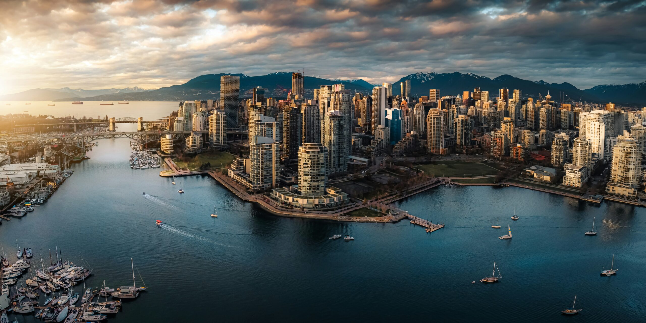 Aerial view of downtown Vancouver at sunset, looking across False Creek to the harbour and the North Shore mountains